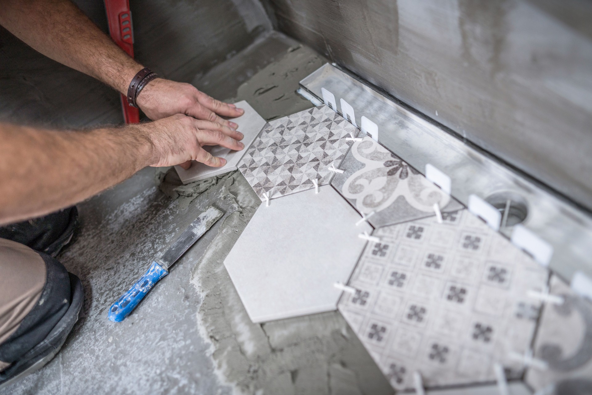 Tiler installing ceramic tiles on the bathroom floor